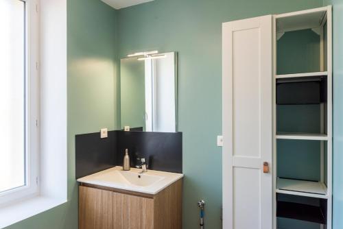 a bathroom with a sink and a mirror at Jolie maison proche centre-ville et plages in Granville