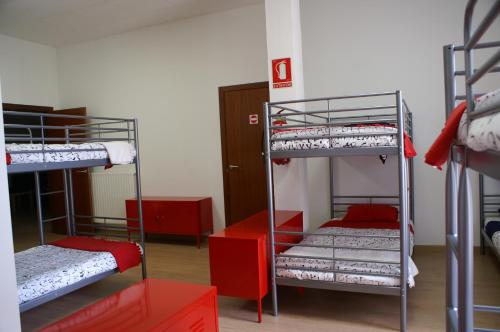 a room with three bunk beds in a room at Grelo Hostel in Ourense