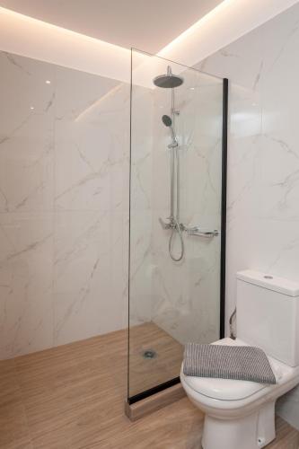 a bathroom with a glass shower with a toilet at Thyme Sea View Apartments by 8essentially in Souda