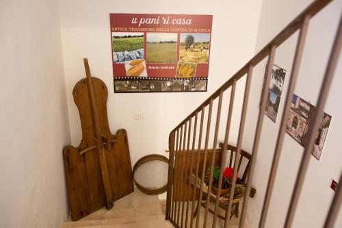 a staircase with a guitar and a poster on the wall at SI-Moutique Le Case degli Avi barocche, con terrazza panoramica in Modica