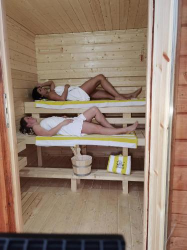 two people are laying in a sauna at PAGA Hotel in Aidenbach