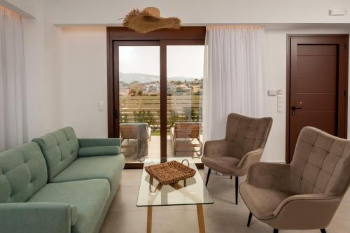 a living room with a couch and two chairs and a table at Thyme Sea View Apartments by 8essentially in Souda