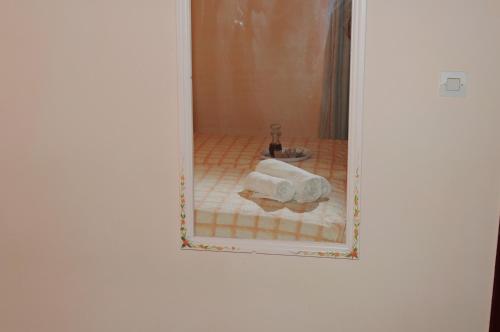 espejo reflejo de un baño con aseo en Papaioannou Aparts, en Loutra Edipsou