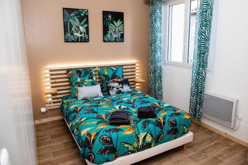 - une chambre avec un lit doté d'un couvre-lit coloré dans l'établissement Cosy Green Clim Wifi Centre ville 2 pers, à Lézignan-Corbières