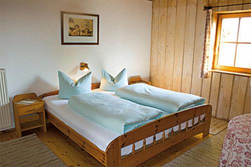 a bedroom with a large bed with blue pillows at Landgasthof Düllhof in Schaufling