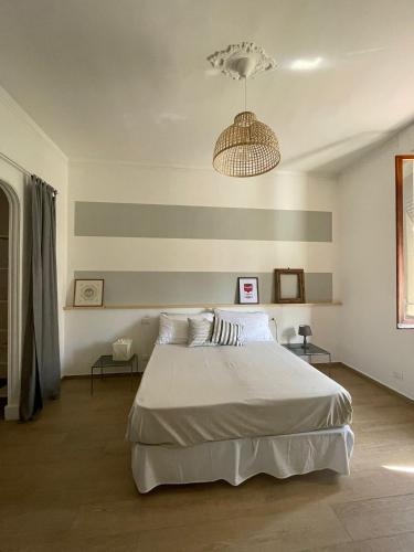 Un dormitorio con una gran cama blanca y una lámpara de araña. en Casetta di Mari, CinqueTerreCoast, en Chiavari