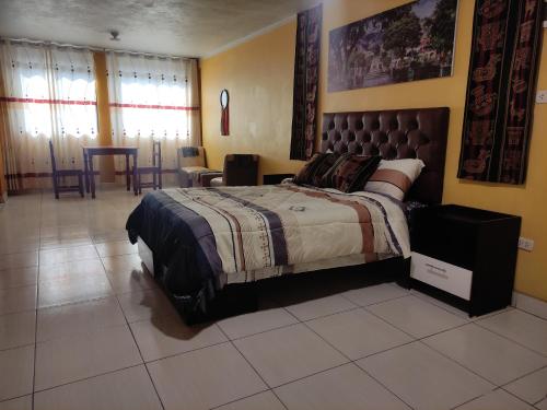 1 dormitorio con 1 cama, mesa y sillas en Casa Sucre Ayacucho, en Ayacucho