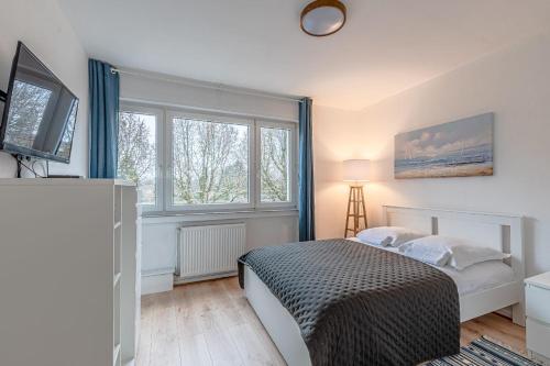 a bedroom with a bed and a large window at Les Trois Frontières in Terville