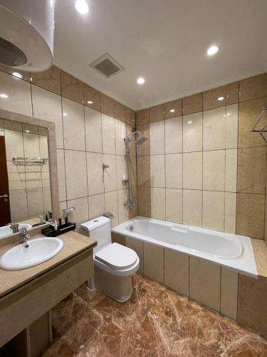 a bathroom with a tub and a toilet and a sink at فندق وريف الشرق in Sarat Abidah