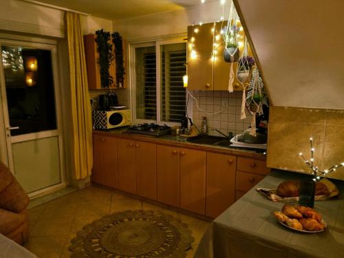 una cocina con armarios marrones y una mesa con un plato de comida en נווה מדבר - אירוח מקומי, en Arad