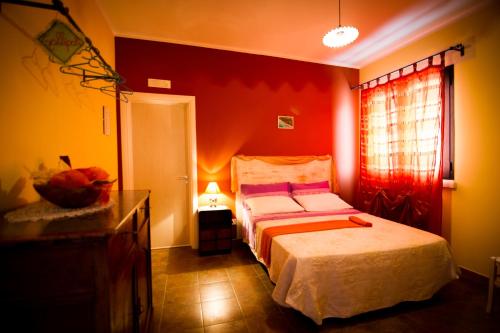 ein Schlafzimmer mit einem Bett und einer roten Wand in der Unterkunft B&B Kilometrozero in Supersano
