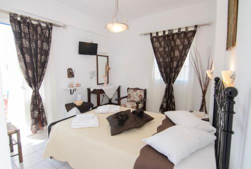 ein Schlafzimmer mit einem Bett in einem Zimmer mit Vorhängen in der Unterkunft Pension Ilias - Chora Amorgos in Amorgós