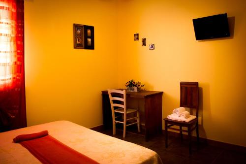 a bedroom with a bed and a desk and a chair at B&B Kilometrozero in Supersano