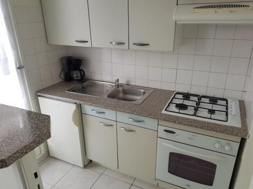 une cuisine avec un évier et une cuisinière dans l'établissement biarritz plage, à Biarritz