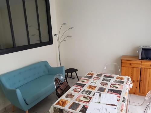 un salon avec une table et un canapé bleu dans l'établissement biarritz plage, à Biarritz