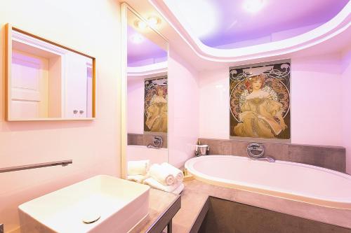 een witte badkamer met een bad en een wastafel bij Wellness Pension Ametyst in Český Krumlov