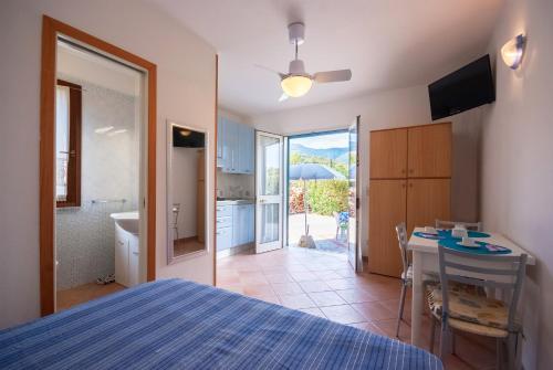 1 dormitorio con cama, mesa y cocina en La casa di Rosetta, en Marina di Campo