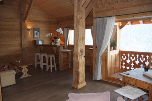 a living room of a log cabin with a window at Le Roy des Montagnes à la Ferme des Ramus in Les Gets