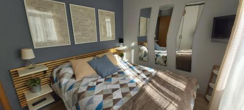 Schlafzimmer mit einem Bett mit einem Kopfteil aus Holz in der Unterkunft Mi casita in A Coruña