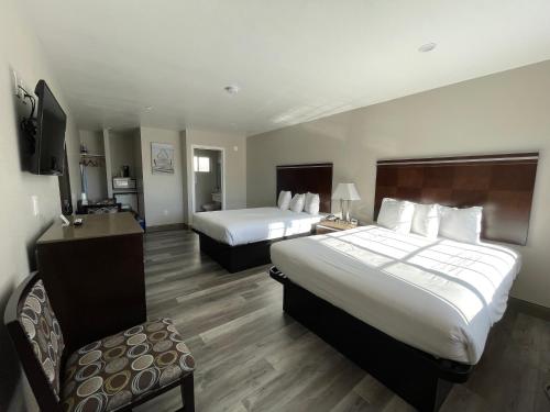 una camera d'albergo con due letti e una sedia di University Inn at San Luis Obispo a San Luis Obispo