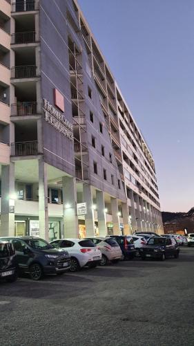 een groot gebouw met auto's geparkeerd op een parkeerplaats bij Manu's Guest Suite in Cosenza