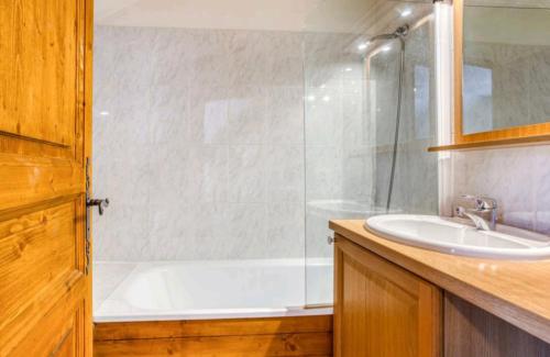 a bathroom with a shower and a tub and a sink at Bel appartement lumineux au pied des pistes in Valmeinier