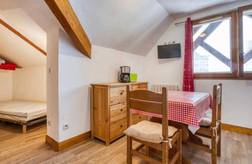 een kamer met een tafel, een bed en een raam bij Bel appartement lumineux au pied des pistes in Valmeinier