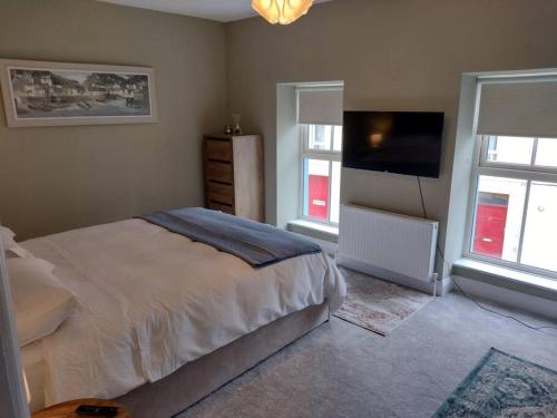 a bedroom with a bed and a flat screen tv at White Birds Townhouse in Sligo Town Center in Sligo