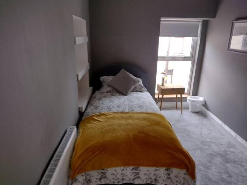 White Birds Townhouse in Sligo Town Center في سليغو: غرفة نوم مع سرير في غرفة مع نافذة