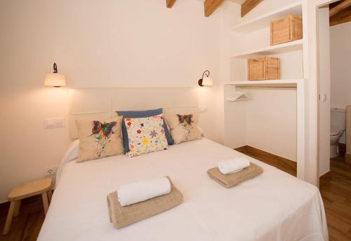 1 dormitorio con 1 cama blanca y 2 almohadas en Villas Sa Ferradura en Cala en Blanes