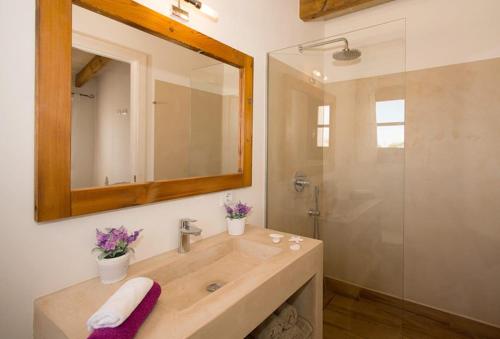 a bathroom with a sink and a shower with a mirror at Villas Sa Ferradura in Cala en Blanes