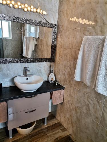 a bathroom with a sink and a mirror at Guest Apartment Monarch in Smolyan