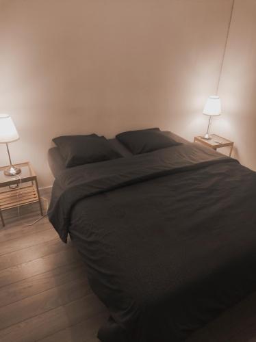 - une chambre avec un lit noir et deux lampes dans l'établissement La musardiere, à Port Santa-Lucia