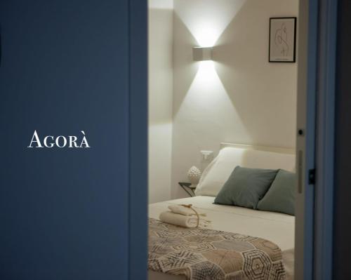a bedroom with a bed and a light on the wall at Agorà Home in Terrasini