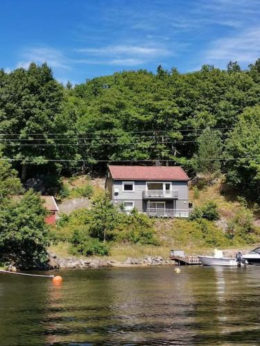 uma casa ao lado de um rio com uma casa em Rolig og idyllisk, men sentralt i Kristiansand em Kristiansand