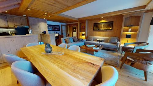 un salon avec une table et des chaises en bois dans l'établissement Résidence Le Lys Martagon, à Val dʼIsère