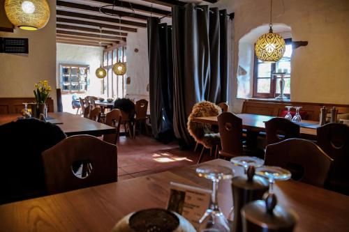 a restaurant with wooden tables and chairs and a window at Landhotel Hofgut Battenberg in Battenberg
