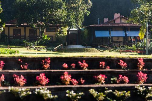 a house with pink flowers in front of it at Pousada Parador Santarém in Itaipava