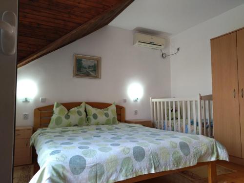 a bedroom with a bed and a crib at Sanja Accomodation in Soko Banja