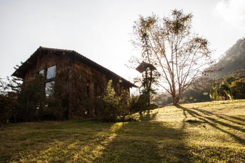 an old building in a field with a tree at Pousada Parador Santarém in Itaipava