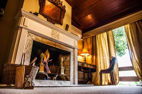 a living room with a fireplace and a table and chairs at Pousada Parador Santarém in Itaipava