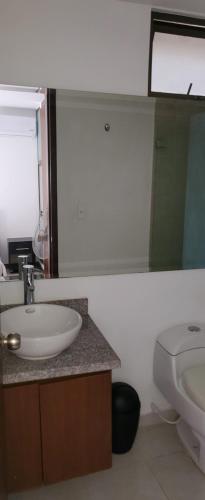 a bathroom with a sink and a toilet and a mirror at SUPER APARTAMENTO AMOBLADO in Neiva
