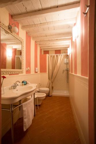a bathroom with a sink and a toilet and a mirror at Podere San Pietro Resort in Castiglion Fibocchi