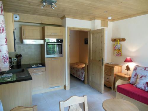 Il comprend une cuisine et un salon avec un canapé rouge. dans l'établissement Alpine Lodge 1, aux Contamines-Montjoie