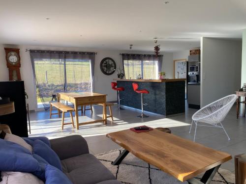 ein Wohnzimmer mit Sofa und Tisch in der Unterkunft Maison de Campagne in Brignac-la-Plaine