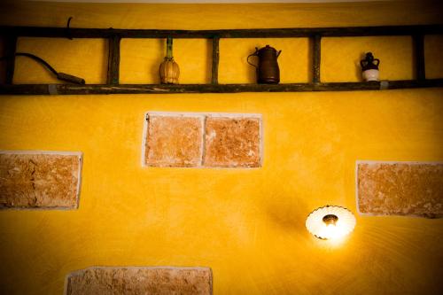 a yellow wall with shelves and a light on it at B&B Kilometrozero in Supersano