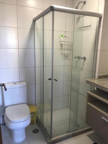 a bathroom with a glass shower with a toilet at Eco Life Beach Class - Muro Alto Flat beira mar in Porto De Galinhas