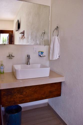 a bathroom with a white sink and a mirror at Carri Surf Studio in Puerto Escondido