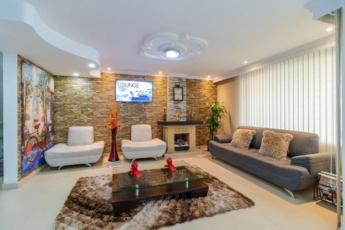 a living room with a couch and a fireplace at Hotel CGH Bogota Airport in Bogotá