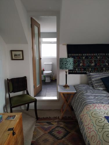 1 dormitorio con 1 cama y 1 silla y baño en Offa Home, en Leamington Spa